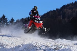 Snowmobiler making a jump with the snowmobile